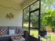 Inviting screened porch with comfortable seating, decorative pillows, and views of the green backyard at 3458 Sagebrush St, Harmony, FL 34773