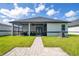 This backyard features a screened lanai, a lush lawn, and a brick paver walkway at 3507 W Jefferson St, Orlando, FL 32805