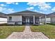 A view of the home's rear exterior showcasing a screened patio and well-maintained lawn at 3507 W Jefferson St, Orlando, FL 32805