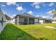 A home's backyard is shown with a screened-in patio with views of the grassy yard at 3507 W Jefferson St, Orlando, FL 32805