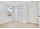 Well-lit bedroom featuring a window, light walls and floors, and a closet with sliding doors for convenient storage at 3507 W Jefferson St, Orlando, FL 32805