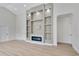 Open-concept living room with built-in shelving, electric fireplace, and laminate flooring at 3507 W Jefferson St, Orlando, FL 32805