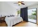 Bedroom with white comforter, sliding glass doors to balcony, and light hardwood floors at 386 Lakeview St, Orlando, FL 32804