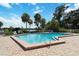 Community pool with brick pool deck, palm trees, lounge chairs, and trees at 386 Lakeview St, Orlando, FL 32804