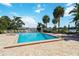 Community pool with brick pool deck, palm trees, lounge chairs, and lake view on a sunny day at 386 Lakeview St, Orlando, FL 32804