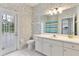 Bright bathroom with floral wallpaper, white cabinets, and exterior door at 4110 Maplegrove Dr, Orlando, FL 32818