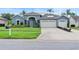 Charming blue home featuring a well-manicured lawn, two-car garage, and freshly painted driveway at 4110 Maplegrove Dr, Orlando, FL 32818