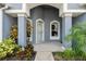 Inviting front porch with decorative columns, arched entryway, and lush landscaping at 4110 Maplegrove Dr, Orlando, FL 32818