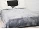 A cozy bedroom featuring a soft gray blanket and a headboard at 4167 Clifden Dr, Ormond Beach, FL 32174