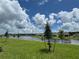Scenic backyard view of a pond with lush green grass and neighborhood houses at 4170 Sagefield Dr, Harmony, FL 34773