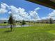 Serene backyard view of a pond surrounded by green grass and neighborhood homes at 4170 Sagefield Dr, Harmony, FL 34773