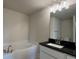Bright bathroom featuring a soaking tub and sleek black granite countertop at 4170 Sagefield Dr, Harmony, FL 34773