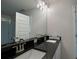 Contemporary bathroom with dual sinks and black granite countertop vanity at 4170 Sagefield Dr, Harmony, FL 34773