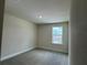 A well-lit bedroom features neutral walls, gray carpeting, and a window providing ample natural light at 4170 Sagefield Dr, Harmony, FL 34773