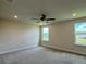 A light-filled carpeted bedroom features a ceiling fan and two windows that offer pleasant views at 4170 Sagefield Dr, Harmony, FL 34773