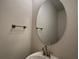 Bathroom with stylish sink, modern faucet, towel bar, and round mirror at 4170 Sagefield Dr, Harmony, FL 34773