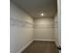Spacious walk-in closet with shelving and neutral carpeting at 4170 Sagefield Dr, Harmony, FL 34773