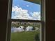 Window view of a serene pond, green grass, and nearby homes at 4170 Sagefield Dr, Harmony, FL 34773