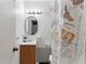 Compact bathroom features a vanity, a mirror, and a shower with patterned curtain at 4654 Alhama St, Orlando, FL 32811