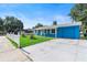 Bright blue single story home featuring a well-manicured lawn, white picket fence, and attached garage at 4654 Alhama St, Orlando, FL 32811