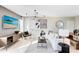Bright living room with modern chandelier, sleek furniture, and beach-themed art, creating a relaxing ambiance at 5015 Starling Bird Ln, St Cloud, FL 34771