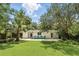 Well-kept backyard features lush lawn, shaded patio with blue seating, and attractive landscaping, perfect for outdoor relaxation at 509 Altaloma Ave, Orlando, FL 32803