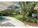Lush backyard with a paver patio, palm trees, and tropical foliage at 509 Altaloma Ave, Orlando, FL 32803