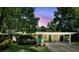 Charming home with a covered carport, vibrant turquoise door, and lush, mature landscaping creates a welcoming curb appeal at 509 Altaloma Ave, Orlando, FL 32803