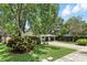 Front yard showcases lush landscaping leading to the home's covered carport, providing a welcoming and verdant entrance at 509 Altaloma Ave, Orlando, FL 32803