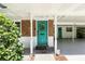 Close-up of the home's charming turquoise front door, adorned with a wreath and framed by brick accents at 509 Altaloma Ave, Orlando, FL 32803