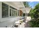 The covered porch features seating alongside the home's white and brick exterior, creating a cozy outdoor space at 509 Altaloma Ave, Orlando, FL 32803