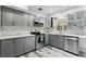 Bright kitchen featuring stainless steel appliances, gray cabinets, quartz countertops, and wooden-style tile flooring at 509 Altaloma Ave, Orlando, FL 32803