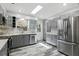 Open kitchen with gray cabinetry, stainless steel appliances, quartz countertops, skylight and unique wood flooring at 509 Altaloma Ave, Orlando, FL 32803