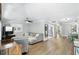 Bright living room featuring hardwood floors, a modern gray sectional, and abundant natural light from large windows at 509 Altaloma Ave, Orlando, FL 32803