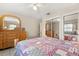 Bright bedroom with tile flooring, mirrored closet doors, and a ceiling fan at 5324 Barefoot Path, Kissimmee, FL 34746