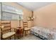 Small bedroom with a bed, two chairs, and a window with blinds at 5324 Barefoot Path, Kissimmee, FL 34746