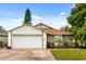 Charming single-story home with a well-maintained lawn, colorful flowerbed, and attached garage at 5324 Barefoot Path, Kissimmee, FL 34746