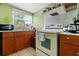 Kitchen with wooden cabinets, tiled countertops, and white appliances at 5324 Barefoot Path, Kissimmee, FL 34746