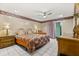 Main bedroom featuring tile floors, ceiling fan and a classic styled bed and matching furniture at 5324 Barefoot Path, Kissimmee, FL 34746