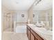 Primary bathroom with a walk-in shower, soaking tub, double vanity, and tile flooring at 540 Vitoria Rd, Davenport, FL 33837