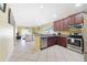 Bright, open kitchen with granite countertops, stainless steel appliances, and access to the living room at 540 Vitoria Rd, Davenport, FL 33837
