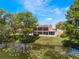Back exterior of the property overlooking the water, showcasing a tranquil setting with a screened patio and lush landscaping at 604 Desoto Dr, Casselberry, FL 32707