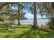 Scenic lakeside lawn view with mature trees draped in Spanish moss and a park bench at 604 Desoto Dr, Casselberry, FL 32707
