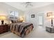 Bedroom featuring window with plantation shutters, ceiling fan, and ensuite bathroom entrance at 748 Duff Dr, Winter Garden, FL 34787