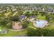 Aerial view of community amenities with a pool, playground, and clubhouse amidst lush landscaping and mature trees at 748 Duff Dr, Winter Garden, FL 34787