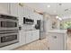 Bright kitchen with stainless appliances, subway tile backsplash, white cabinets, and island offers ample counter space at 748 Duff Dr, Winter Garden, FL 34787