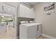 Convenient laundry room with washer and dryer, storage cabinets, and view to the kitchen at 748 Duff Dr, Winter Garden, FL 34787