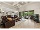 Bright living room boasts tile floors, recessed lighting, and leather furniture, open to the outdoor pool area at 748 Duff Dr, Winter Garden, FL 34787