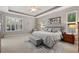 Inviting main bedroom features neutral tones, tray ceiling, ceiling fan, bench, and windows with plantation shutters at 748 Duff Dr, Winter Garden, FL 34787