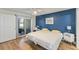 Bright bedroom with a blue accent wall, two beds, and sliding glass doors to the outside at 7856 Sugar Bend Dr # 7856, Orlando, FL 32819